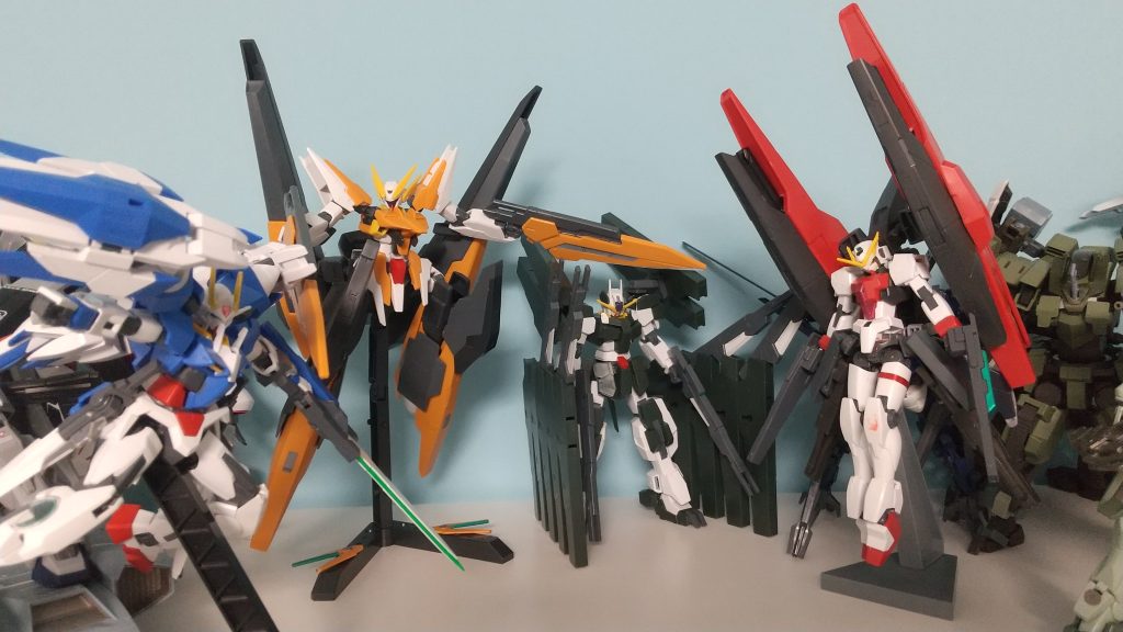 最後にソレスタルビーイング機体で集合写真。股関節がふにゃふにゃなせいで、なんか女々しいポージングになっとる今回の反省点いつもの作りの雑さと、属性を盛りすぎ。どんぐらい盛ったかというと、・長距離砲撃はGNメガランチャーⅱ(アーチャーのバインダー)、腰のGNキャノン、ライフルと合わせて一斉射撃可能。・中距離はビームライフル(アーチャー)、ビームライフル(ラファエル)、GNスパイクビット、アーチャーのバインダーのミサイル・近距離は普通のビームサーベル、ライフル、腰キャノンからもサーベルは生やせる、GNピストル(上から三枚目の写真で構えてます)・本体は光学迷彩で透明になれるし、GNフィールドは展開可能・疑似太陽炉3基持ってる( 配置はバインダーに2基、アルテミーぽくリアスカート下に1基)、試験的にライザーソードが使える・ヴェーダ取り返したんだし、当然トライアルシステムが使える・機首パーツ持ってくれば、ハルートと合体可能(アリオスは撃墜されましたので)という感じ、前回同様マジでエースパイロットの上澄みしか使えん…
