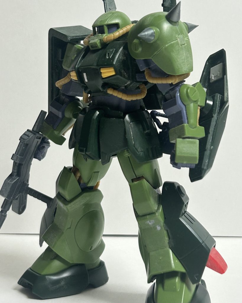 今回は!塗装前の写真があるのです。まぁ、この後トラブルやら何やらでこの写真とも違うんですけどね…。。プロポーション的にガッチリして良い感じなので特にプロポーションは弄りませんでした。とりあえず加工箇所は……。頭部。当初、パッケージの写真を見るに相当頭でっかちに見えたのでザクⅡの頭を使おうかと思ってました。が、実際に組んでみたら違和感を覚えるまでも無かった為、そのままキットのを使用。頭のど真ん中に合わせ目かつモノアイレールははめ殺しの為に後ハメ加工しました。後ハメについては別途写真参照のこと。胴体。基本そのまま。プラ板でごま塩程度にディテールアップ、胸部カメラのモールドが小さ過ぎに思えた為溝を大きくしました。あと、腹部を後ハメ出来るようにしたけど、正直、しなくて良かったかも。で、塗装中にエアダクトがぶっ飛んで紛失→応急的にWAVEのバーニアのアップグレードパーツからエアダクトを作ってでっちあげました。それプラス、パイプが千切れた為、グフのパイプを加工して使用しました。腕部。素材の味。左肩のスパイクを公式のアップグレードパーツに置き換えました。右肩は上から見るとポリキャップ丸見えなのでカバーを作成……左はスパイクアーマーがあるから良いや、と無視。別途写真あり。腰部。ほぼそのまま。股にある元々のスタンド穴が角形状のみに対応している為、ポリキャップ仕込んで3ミリジョイントのスタンドに対応できるように。あとはヒートホークを懸架出来るようにしました。脚部。基本は変わらない。爪先を開口して奥にスラスターダクトっぽい物を作成しました。脚部スラスターのモールドが浅い為、いっそのこと開口しました。