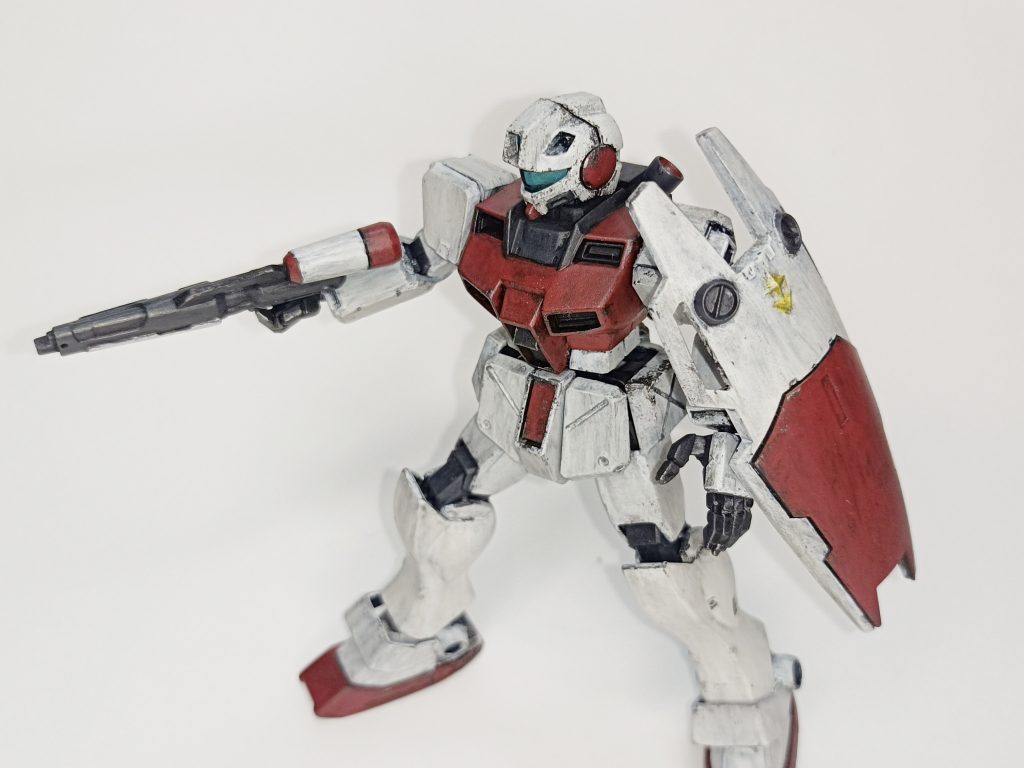 箱絵風のポーズ。 ↓使用した塗料↓〈水性ホビーカラー〉グランプリホワイト（本体）あずき色（赤2号）（本体）RLM75 グレーバイオレット（ビームスプレーガン、関節）〈その他〉Mr.フィニッシングサーフェイサー1500 ブラック（下地、各パーツ裏面、胴体ダクト部分等）Mr.ウェザリングカラー マルチブラック（ウェザリング）タミヤエナメル ガンメタル（チッピング）タミヤエナメル クロームシルバー（チッピング、頭部バイザー裏面）Mr.スーパースムースクリアー つや消し（トップコート）頭部バルカンはサフそのまま。腰アーマーやシールド裏などの塗装もサボれてにっこり。