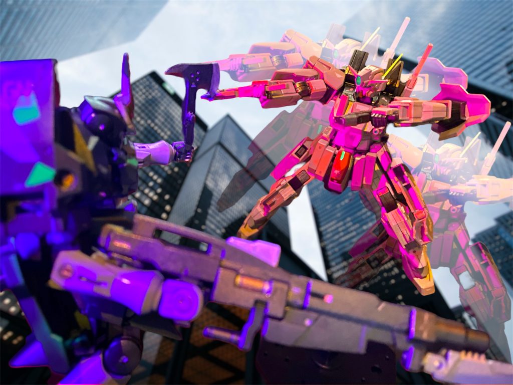 「さすがに“戦場の職人”だな。ならお望み通りこっちから打って出るしかないか!ハロ、トランザムだ!乱れ射つぜ!!」 死角から出ると同時にトランザムを発動させたケルディムサーガは、7丁の銃を駆使しながらACTVジンクスを追い詰めてゆく。レイモンド機は肉薄されてGNアックスで応戦するが、トランザム状態のライルの早撃ちには間に合わずコクピットを撃ち抜かれた。