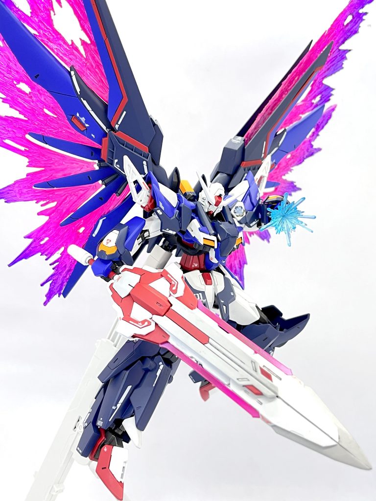 そして光の翼を展開‼️機体をゴツくするに伴って翼も大きくしようと思い、上からライジングフリーダムの翼のパーツを取り付けたのですが普通に光の翼を展開するとその部分だけ妙に浮いてしまうことに気づきました。ということで上部分の光の翼を透明プラ板とグルーガンを使ってスクラッチしました!これが結構評判良くて、元のデスティニーのキットの一部だったんじゃないかと誤認してくれる人が多かったです( *´꒳`*)グラデーションも相まってメタルビルドver.の光の翼っぽくなり、翼だけで28cm程の大きさになってくれるので展示会でかなり映えます✨️