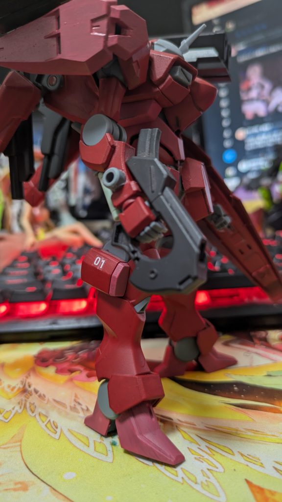 主武装はザウォートと同型のビームガン。学園リミッターは外されているので緑ビームではなくピンクビームが出ます。近距離での取り回しに優れ、速射性も高いので主武装として選択されています。肩の増加装甲はスラスターを内蔵しており、フレキシブルな可動をすることで高速機動時でも安定した姿勢制御を実現します。