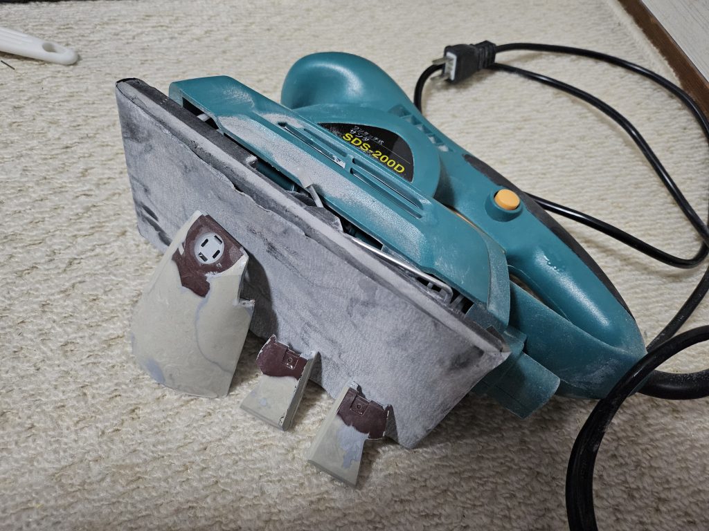 延長作業中のリアアーマー&サイドアーマー。プラ板とエポパテの塊です。ガンプラ作りにはまず出てこない工具〈電動サンダー〉で一気に削って形を整えました。