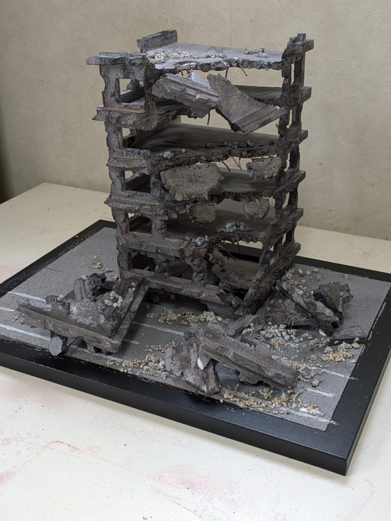 汚して瓦礫みたいな感じで切り落とした部分を置いてみる。そして道路部分はコルク板をひいて灰色に塗装後にマスキングして白線をそれっぽく描いてみました