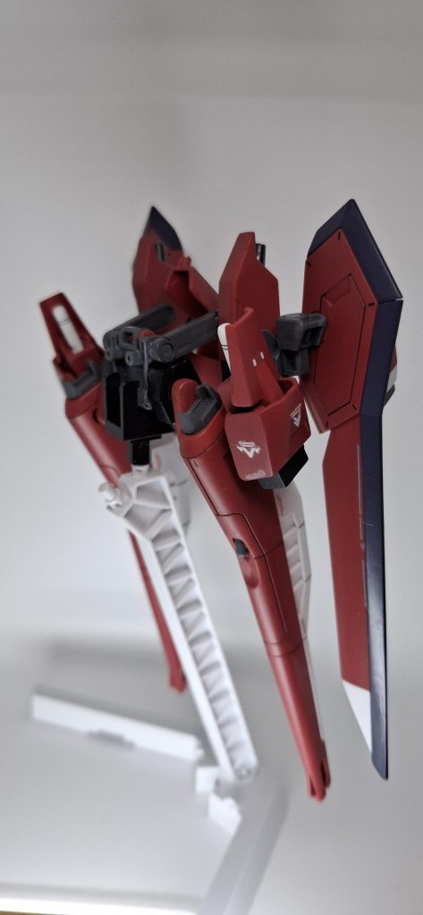 そのままだとMS形態では背中の名無し砲を正面に向けて撃てない構造が気になったので、元々の接続軸を切り飛ばし良い感じの位置へ変えつつジャンク品から延長ジョイントを探して取り付け、MS時でも正面に向けて撃てる様に変更。セイバーからアムフォルタスと接続ジョイント付近のスラスターをいい感じに短く切って加工し接着、セイバーの羽は回りに干渉して邪魔なのでオミット、変わりにヴァンセイバーを参考にしてビームサーベルラック+スラスターを制作して取り付けブーメラン投げても近接戦闘可能な仕様に。アムフォルタスを展開するとサイドアーマーが干渉するので薄いセイバーのものに変更、ビームブーメランのマウント位置も下げました。