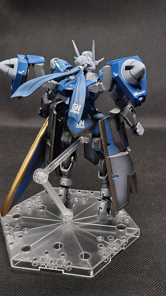 ｢GNお団子｣頭部に取り付けられた第3の太陽炉、両肩のツインドライヴシステムから独立して稼働していてGNアヴァロンに粒子を供給している髪飾りはクラビカルアンテナ、鎖骨じゃないけどクラビカルアンテナ。粒子の制御力を上げるために大型化している、背面からのビーム攻撃を減衰または反らす効果もある30mmのマント&マフラー、塗装で陰影つけたけど照明で分かりにくい😭