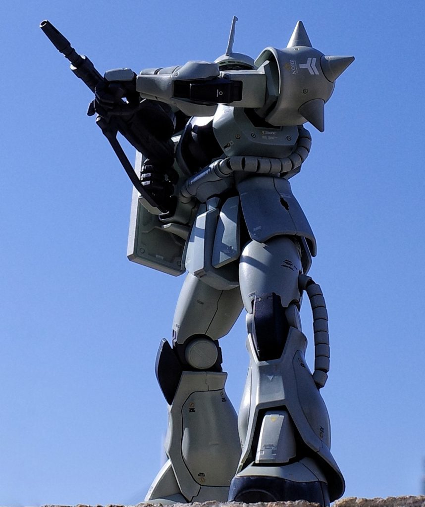 ポーズはファーストガンダムの第一話、アムロが飛び乗って起動した直後のガンダムの正面にいて振り向いたジーン機を真似てみました(ジーンは伍長とされ中隊長などではありませんし乗機もJ型のはずがありませんけれど)。構えを作るためにザクマシンガンのストックは外しています。