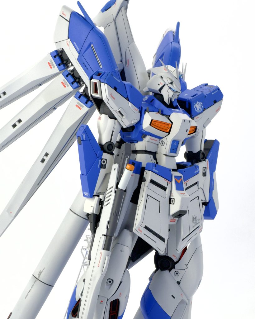 ○頭部逆襲のシャアベルトーチカチルドレンのコミック版ハイニューガンダムの顔を目指し、旧MGのマスクを基にしてパテで形状を整え、顎もシャープな印象にしてみました。トサカ部の形状変更も行い、私好みの頭部に仕上げました。○胴体普通に組むと襟部分が顔を若干隠す設計となっておりますが、襟の形状を変更し、首の基部を延長させて頭部が綺麗に見えるように、より自然でスッキリとした印象を目指しました。前述の改修に加えて、白い肋骨パーツをパージ、胸部ダクトフィンの小型化、ウェスト延長を施して上半身のボリュームダウンを目指し、腰部フロントアーマーの大型化と、S字立ちになるように股関節基部を前方へ移動させる加工を施しております。そうする事でハイニューRG版のようなどっしりとしつつもスタイリッシュな印象が出せるよう試みました。フロントアーマーのパネルラインはコミック版に寄せて一新してみました。ver.Ka特有のモールドを除去、全体を見てもらえるようにパネルラインもシンプルな印象に。○腕部がっしりとした印象を出す為に、いかり肩となるよう肩アーマー接続部分にスペーサーを入れました。モールド除去、パネルラインの追加も行っております。○脚部どっしり感が損なわない程度に脛〜裾あたりを延長して形状変更を施しました。足首にスペーサーをかまして、延長しております。