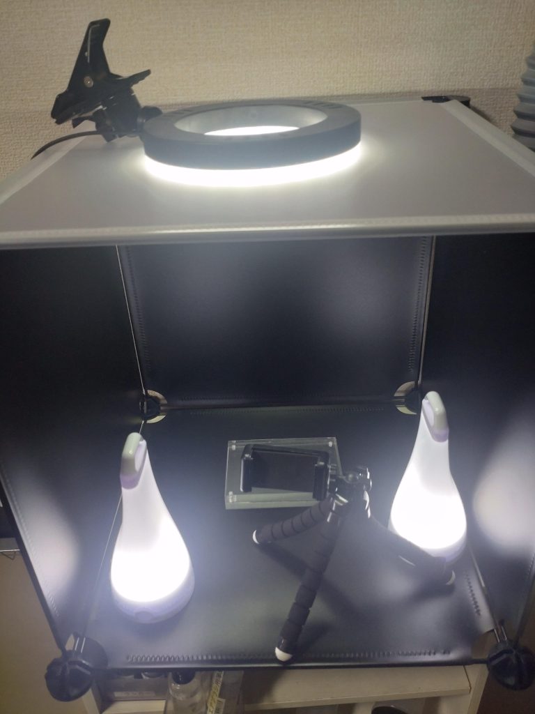 撮影が全然うまく行かないので、簡単撮影ブースを用意しました。ダイソーの組み立てラック：黒4枚、天井のクリアー1枚、ジョイント2セットで700円、サイドのランタン2個で600円。フレキシブル3脚200円。以上がダイソー天井のリングライトは以前デスク作業用に購入したものでたしか2000円ぐらいだったと思います。光が強いんでしょうか。テカテカするので試行錯誤してみます。