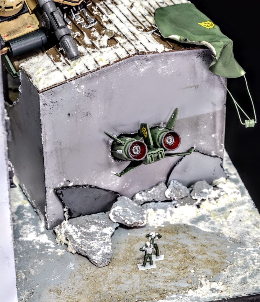 倉庫の屋根には脱出した際に使ったパラシュートが引っかかっており、パイロットを後ろから同僚の兵士が助かって良かったと慰めています