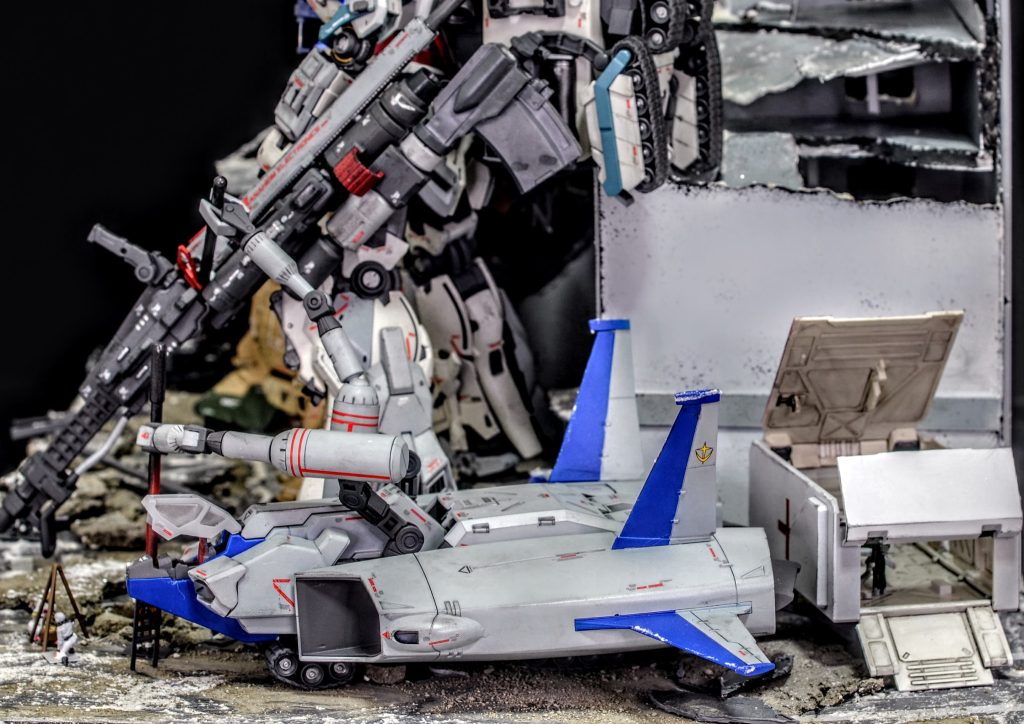 機体下部のキャタピラによる陸上移動が可能で、ナラティブのそばまで自走して作業アームでライフルのバレルを交換しています