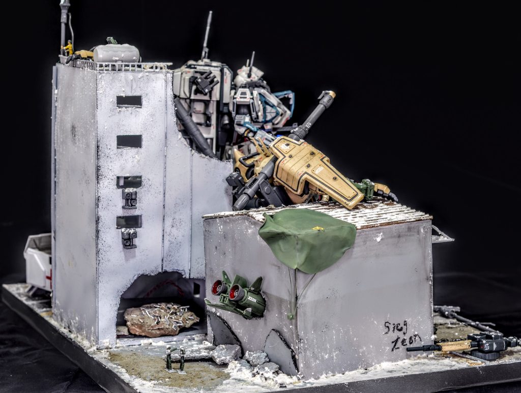 ザクが擱座した倉庫の裏にはジオンの戦闘偵察機が衝突して突き刺さっており、無事に脱出したパイロットが愛機の変わり果てた姿にショックを受けて頭を抱えています