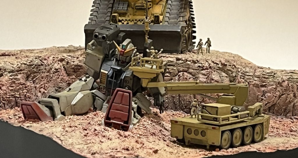 この写真はスマホを横にして是非眺めて下さい!陸戦型ガンダムのやられっぷりを解くとご覧下さい。ヽ(´o`;《ガンダムの肩に装着されているのは…》光学式有線誘導対MSミサイル。サイド7にて強行偵察を行なったザクに対し使用された元々は対戦車用ミサイルを対MS用に大型改良したもの。ザクの正面装甲を貫通できるとされている。有線誘導のためミノフスキー粒子散布下でも遠隔誘導に影響が無いとされているがパイロットが弾着までミサイルから発せられる光を照準器で捉え続ける必要がある。そのため誘導中に反撃される可能性があるため待ち伏せによる使用が主な戦術となる。