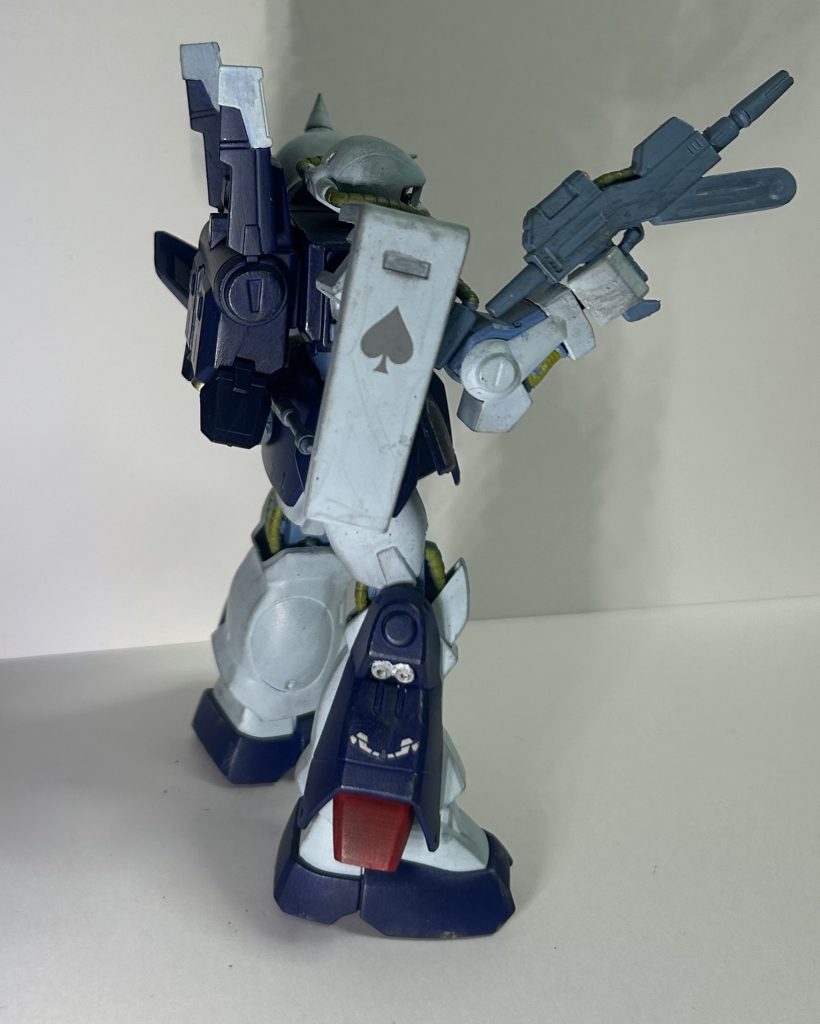 塗装は黒サフ吹いて、筆塗りではいつものアクリルガッシュ。カラーリングとしては連邦仕様をイメージしました。理由としては、緑のカラーリングは相手への心理的効果を狙ったとかあるけど、10年も経ってない以上むしろ連邦の兵士の方から相当緑のカラーは嫌悪感を覚えられているのでは?と言う論理から。もっとも、HGの方で出ている連邦仕様は個人的なイメージとしてはミスマッチだった為、水色マシマシで。カラーイメージとしては以前見た当時のパッケージアート(多分)的な?感じ。色調はいつにも増して、説明が難しい……。水色は白大量に100金で買ったアクアグリーンとほんの少しの黒。胴体部他は紺色にほんの少しの黒。関節部他は白に少しの黒と青……だと思う。パイプはそれに黄色を混ぜたもの。後、バーニアとかインテークの内側はセラミック素材をイメージしての白塗装です。何故、そう言うふうに曖昧なのかと言うと、色調しつつ塗り進めたからです。最初にパレットに絵の具を各色出してペインティングメディウムで伸ばし少しずつ混ぜながら塗ると言う方法です。一番顕著にそれが出ているのはパイプ類かと、場所によって違いが出て良いかなーっと言って感じで(実際に見てor写真で分かるとは言ってない)