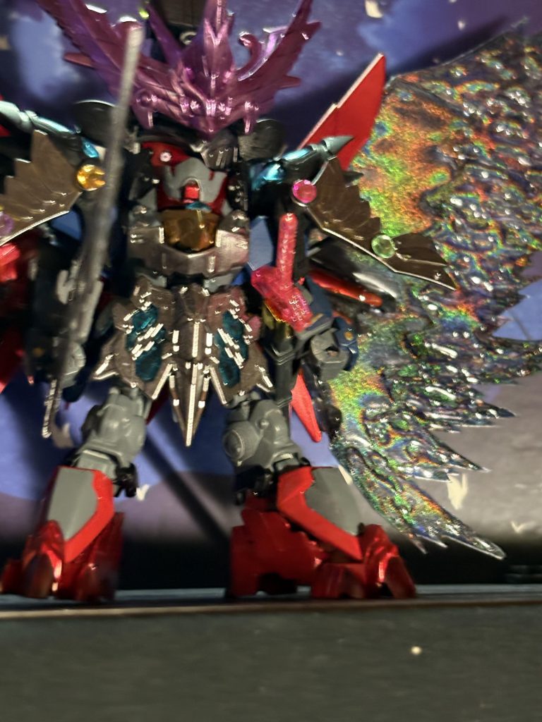 翼は百均で購入した透明下敷きを形に切って、黒と紫のレジンを使ってエフェクトっぽくし、ガンマカトランザムレッドを吹いてます結構重くなりましたが、きちんと自立しています