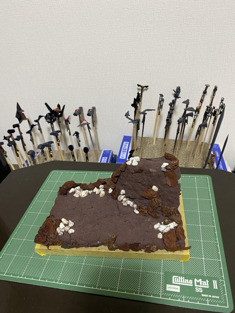 素材のままの状態。ボンド水でガチガチに固めてます。もっと早く界面活性剤の存在を知りたかったが、時すでに遅し。次は洗剤も混ぜて使おうと思います笑着色は下地に黒の絵の具、メインはタミヤアクリルのデザートイエローをムラ有りきでテキトー塗り。出した分の塗料が余ったのでビシャビシャにしたら、乾く時にヒビ割れて意図せず良い感じになったのでボーナス経験値獲得。ウェザリングカラーのグランドブラウンで影を入れて、うすめ液でぼかし。ハイライトはアクリルガッシュのパステルサンド。ドライブラシやり過ぎて想定よりも全体が白っぽくなってしまった…笑