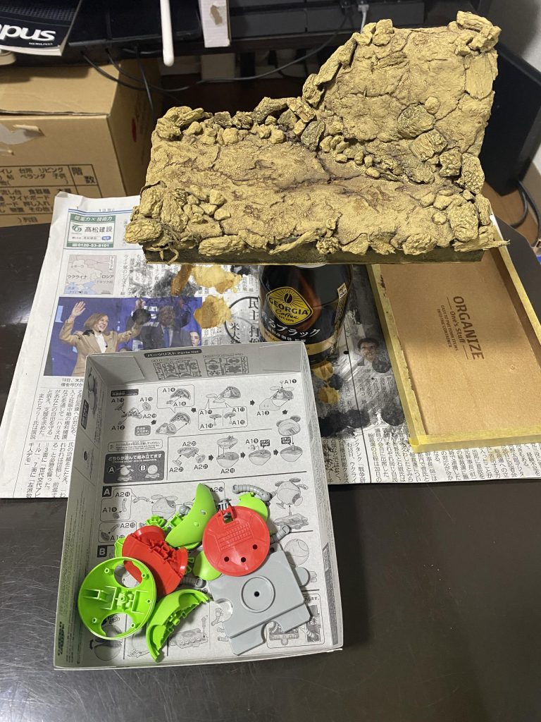 ジオラマはほぼ100均素材で作りました。土台はスチレンボードを適当に重ねて段差を作り、上から粘土を貼り付けました。最初は木粉粘土とやらを使ってみたけど硬くて扱えなかったので、結局ジオベースにしました。専用の粘土だけあって使い易さが段違い。岩ころはバークチップと水槽用の小石。小石の粉が凄くて使うのやめようかと思った笑