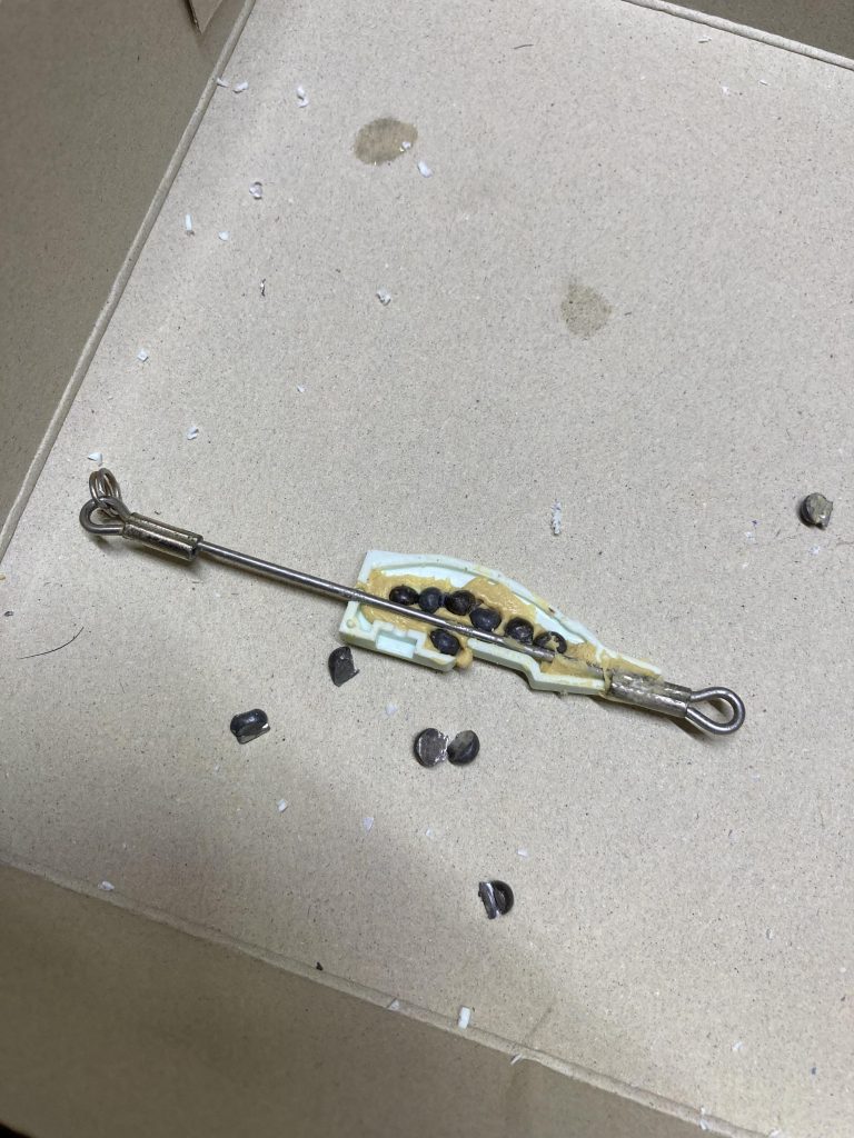 パテで金属棒を固定して、ついでに釣り用のオモリを入れました。