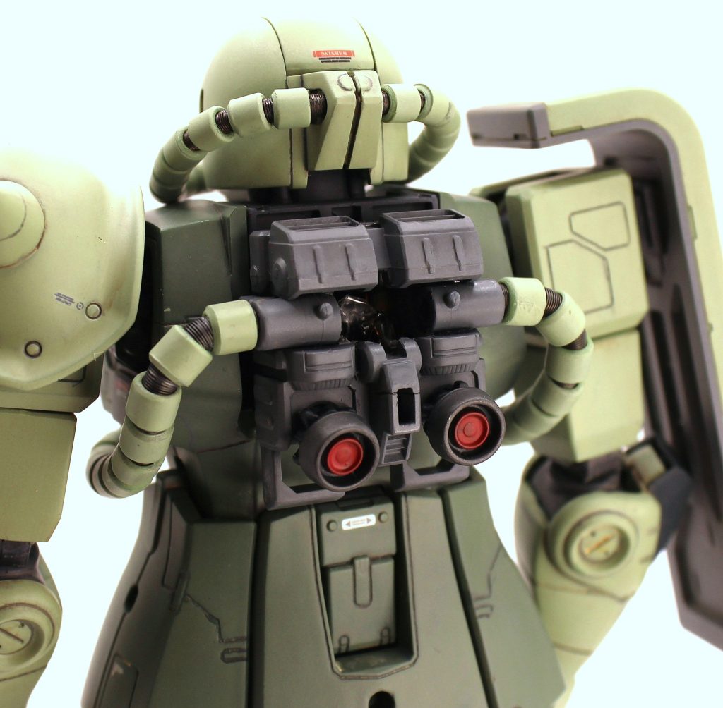 モノアイに仕込んだLEDから首を伝って配線を這わせ、胸部内部の電源に繋げています。F2ザクより電池スペースが狭く、電池ケースも必要最低限まで削り込みテープで絶縁＆シーリングして何とかビルトインさせました。バックパックのメカ部に穴を空け、この状態でスイッチON/OFFができます。はらわた引きずり出した画像は制作途中にありますので、もしご興味あればご覧ください。