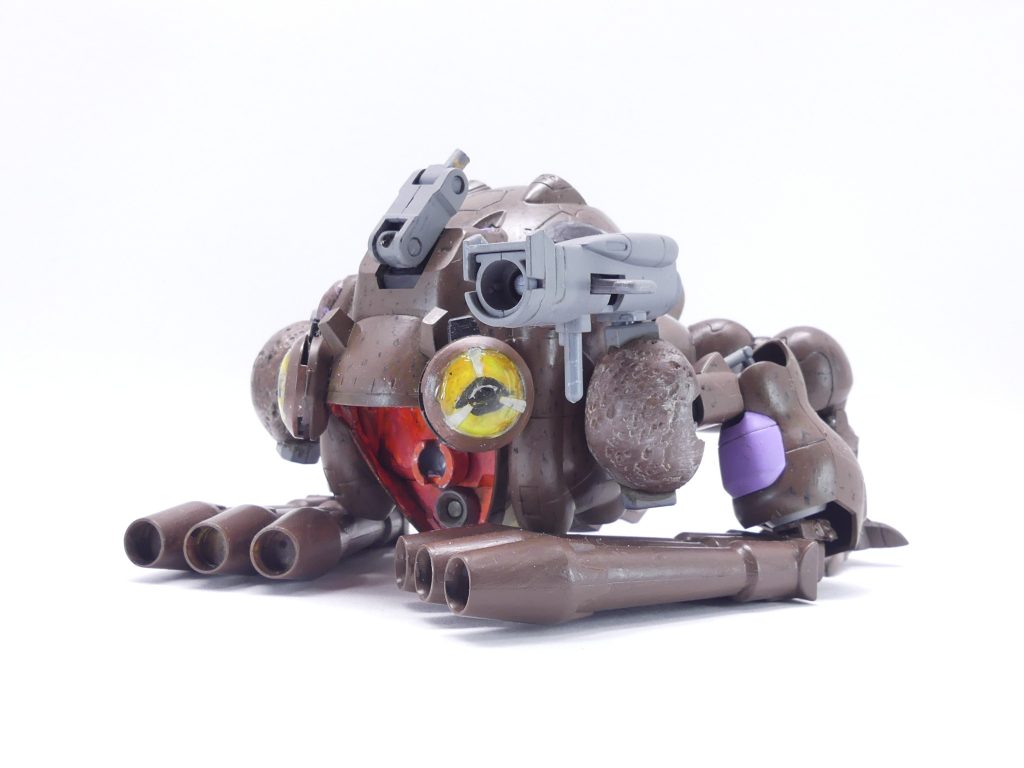 大蝦蟇グシオン：「さあさあ、お立ち会い！」「ガンプラ魔法」と同様のプロセスで「召喚」される蛙型プラットフォーム。基本的にはガンダムグシオンを寝かせて蛙っぽくしただけとはいえ、本機のパワー面はこちらに集中される。ナノラミネートアーマーによる全身の防御力に加え、目部分はメリクリウスのプラネイトディフェンサーであるため（「カエルの目ってかわいいよね…」）正面からの攻撃にはめっぽう強い。反面、蛙型メカにありがちなジャンプ力など機動性は皆無。「ヒキガエルは待ち伏せ型、そういうもんなんだよ」とはユマの弁。塗装時のモデルはアズマヒキガエル。前から。グシオンを寝かせて一部をパテで埋め、前足を董卓ザクから、後ろ足を（ちょうど良く手に入った）ＢＢデビルガンダムから流用。口は開きっぱなしで固定。