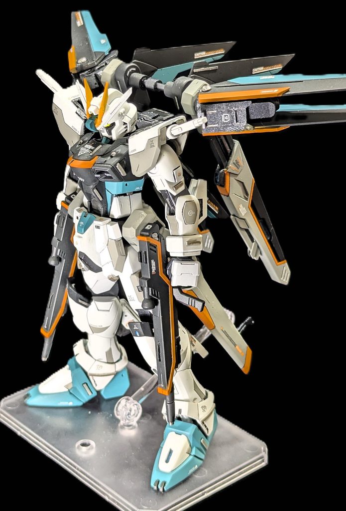 まずは全体から。基本は旧HGフリーダムをベースに、ウイング部分はバラバラにしたのち、航空機型に改めて造形しました。腰部はレールガンと思いきや、プラウドディフェンダーに搭載されていた「精神感応型ナノ粒子高電圧」の試作品を装備している設定としています。肩部はセイバーと同じように、ビームサーベルを格納させました。この形状がかなり好きで、前作ジャスティスから引き続き導入しました。フェイスパーツは、コレクションシリーズのストフリから流用しているため、（不人気な）アニメ風となっています。令和ではイケてないかもしれませんね。