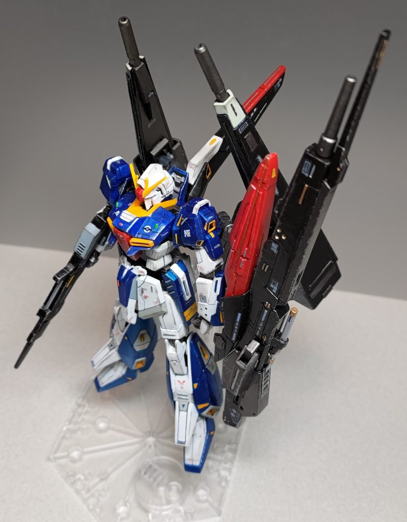 俯瞰ぎみに。青地や黒地の部分はスジボリわかりづらいですね・・・サイドスカートにΖⅡみたいな意匠を追加したのはお気に入りポイントです。下記のようにパーツ交換してます。・背面のフライングアーマー ⇒ バトルアームアームズのアームとギャプランTR-5フライルーのバインダー・ボディ背面パーツとフロントスカート ⇒ HGUC203番Ζガンダム(ジャンク品)・手首パーツ ⇒ 次元ビルドナックル(角)デカールやメタルパーツはコツコツため込んでた素材を多めに使いました。せっかくの主役機コンですからね。特に前腕部の3Dメタリックシール2(青色)はメタリック塗装と合わせて良い味を出してると思います。