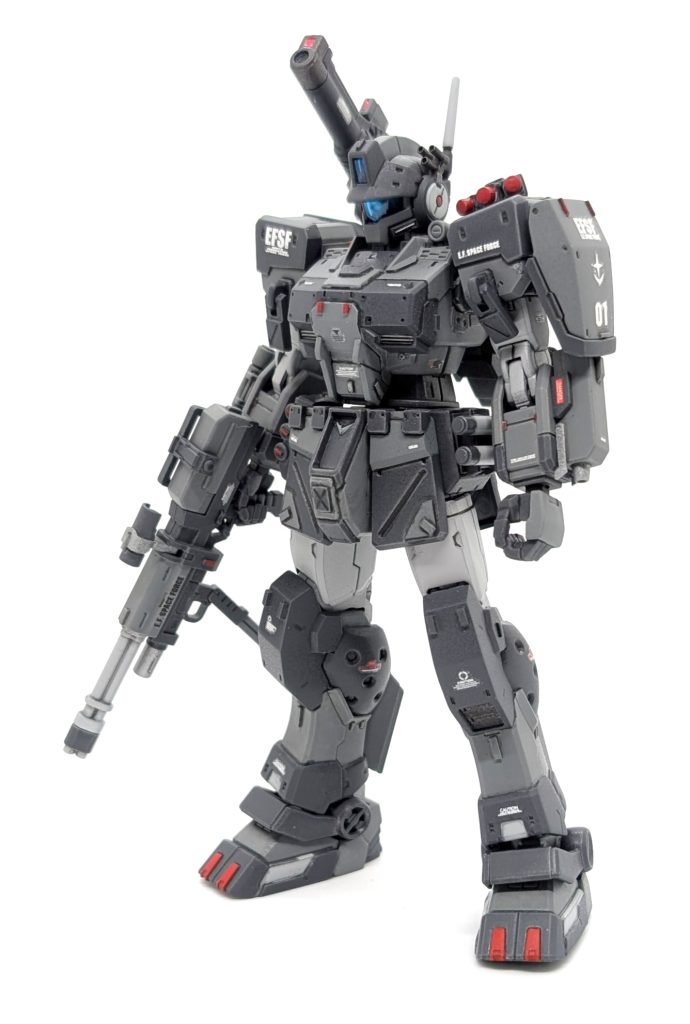 まずは素立ち。写真だとちょっと分かりにくいですが、グレーの中にレッドを散りばめ、少し威圧感があるようにしてます。足元(爪っぽいとこ)など、真下から敵歩兵が見たとき恐怖感を与えるような印象にしました改造点はあまり無くて、武器の配置換えが中心です。ビームサーベルのラックを腰に付けたり、コトブキヤのディテールアップパーツで3連グレネードみたいのを肩に付けたり、局地型ガンダムのキャノン砲を付けてみたり、左腕に試作型のような腕部ビームガンを付けてみたり…あと、密林と違って市街地だと隠密的な行動ができないと仮定して、コクピットのアーマーまわりに増加装甲を足し、防御力が向上してる感を出してみました✌️