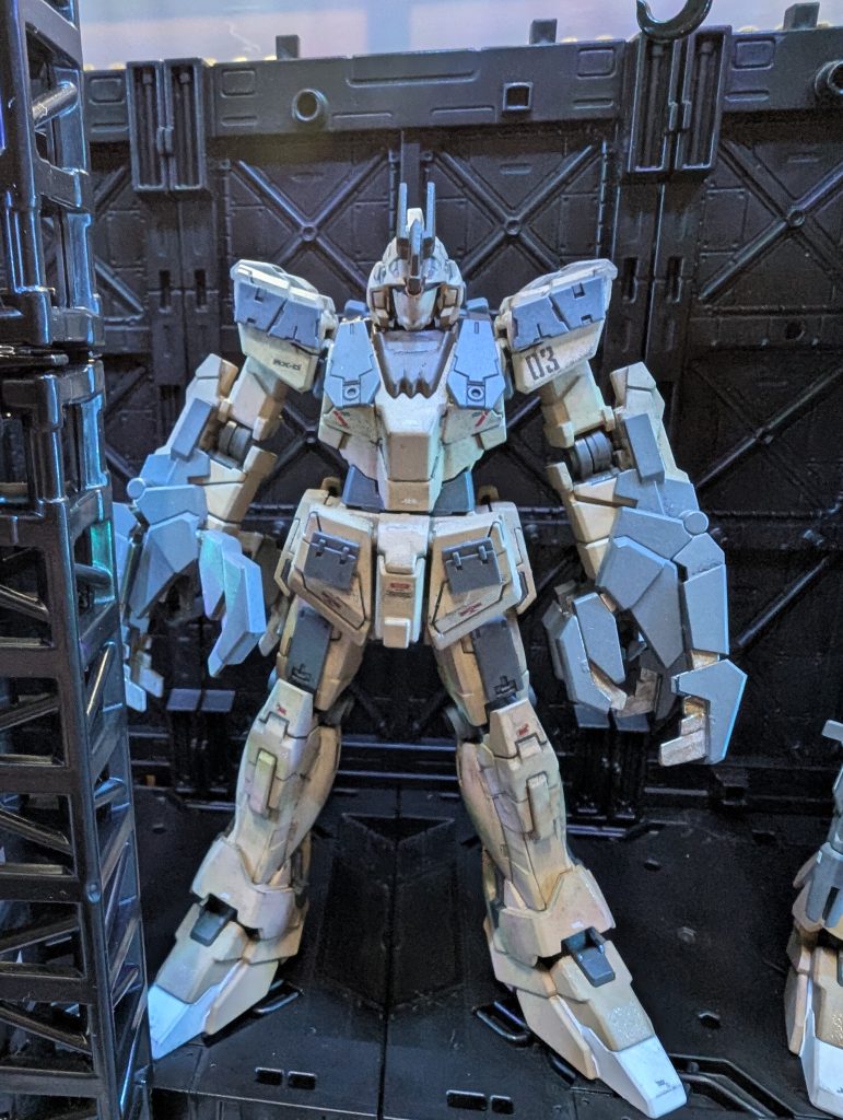 03番機両腕にアームドアーマーVN(ヴァイブロネイル)を装備。射撃兵装の使用は不可だが、近接戦闘時は敵機はバラバラに引き裂かれていく。目標に接近せざるを得ないため、機体各所にウェアラブルアーマーを装着しているが、これは防御力向上の為ではなく、装甲がユニコーンのパーツ割りのままになっているため、被弾時の装甲の「ズレ」が発生するのを防ぐ、「当て布」にすぎない。