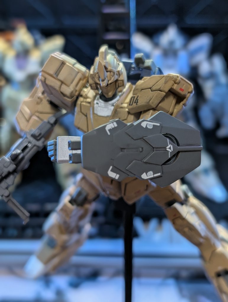 Iフィールド・バックラーユニコーンガンダムの携行するシールドを小盾サイズにした物。防御面積が低下した分、実弾兵器に対しての防御力は低下しているが、Iフィールド発生器は搭載されている為、ビームに対しての防御力は健在。ジェネレーターに直結したビーム・サーベルが装着されており、同時稼働は出来ないが斬撃を放つ事が可能。