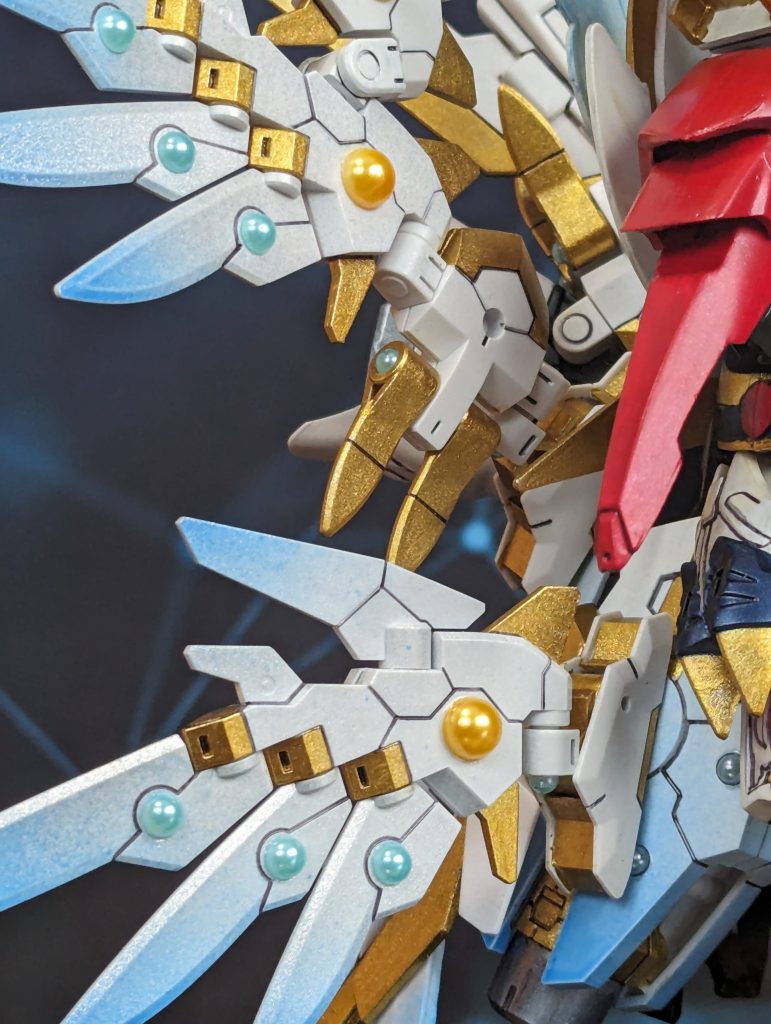 羽にはクリアブルーを端だけ吹きかけシャインシルバーでコーティング。装飾には女性用のネイルのパーツをチョイスしました。ネイルの部品は形も様々あり今回はパール状のモノをチョイス。モノアイ等この形状ならプラモデルでもよく見られる形なので違和感が少ないかな。