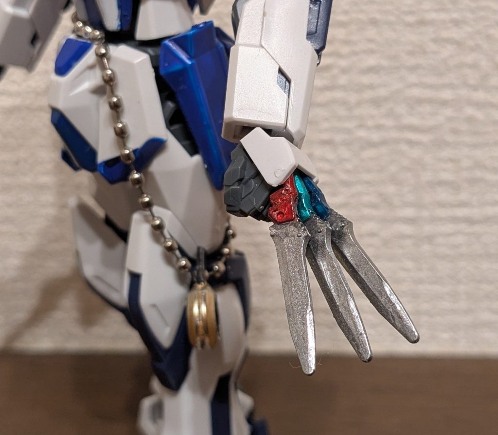 手首アップ。咲夜の特徴的な、指にはさんで3本のナイフを持つ姿を再現。カミキバーニングの手の甲の下部を削除して穴を広げ、そこに合うようにグリップ部分を加工したストライクのナイフを3本差し込むことで、指にはさんで持っているように見せてみました。ナイフ自体も、グリップをロイヤルメタレッド、メタリックグリーン、コスモメタブルーで塗り分け、刃の部分はメッキシルバーです。 で、もうひとつやってみたのが一緒に写っている懐中時計！カミキバーニングの余ったドーナツ型パーツ（ビルドバーニングの肩接続部）を加工して２枚合わせ、Gフレームのつま先を加工して接着し、その穴にキーホルダーのチェーンを通し、腰に巻き付けました。咲夜が腰から下げている懐中時計に見えるかな〜て感じです。