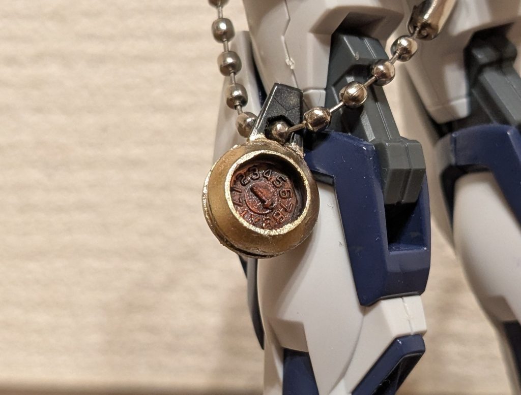 懐中時計のアップ。時計の文字盤も再現してみました！見て分かりますかね？コレ、ランナータグに付いているショット月表示の文字盤です！円にそって切ってみたら、この丸のパーツにピッタリ収まるサイズ！！それはもうこう使ってくださいと言わんばかりにカッチリ笑あとは表面の文字や模様を墨入れしメインカラーはビルドバーニングのクリアオレンジそのまま。裏面をメッキシルバーで塗装しました。