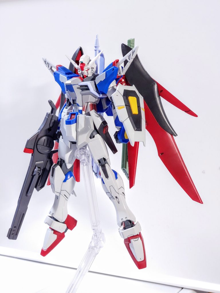 改修は以下の通りです。首1mm、胴体3mm、太もも2mm、足首1mm延長股関節1mm，翼の付け根を2mm幅増し頭部をガンダムヘリオスのものに交換、マスク、頬当のライン変更フロントスカートを旧HGデスティニーよりバランス調整して移植胸部にプラ板を貼りボリュームアップ肩部など一部にディテール追加レールガンは以前ストライクフリーダム弐式の時に作成した2cm短縮したものを持たせました。