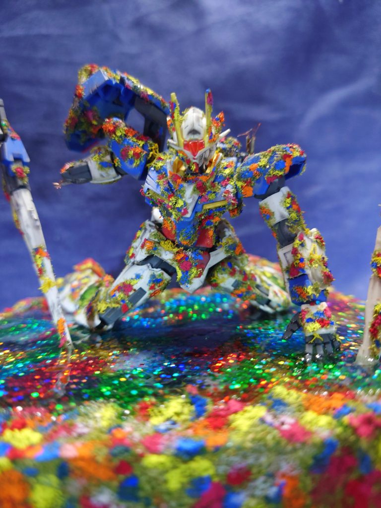 機体のサイズ感に合う花が無かったので、100均のジオラマ用の草っぽい素材をボンドで貼って絵の具で色付けして表現。足元は手芸用のラメチップを散りばめてレジンで水面を表現。