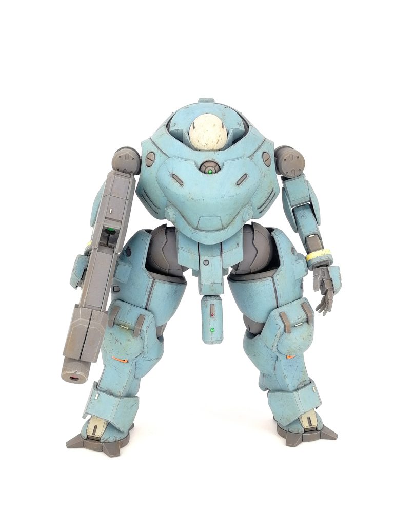 塗装はフレーム色のメカサフヘヴィまでエアブラシで塗装し、ドライブラシ、オイルブラッシャーで汚しを軽く入れた後一度クリアでコート。その後メイン色をファレホで筆塗り、この際化粧用のぼかし筆とスポンジ筆を使用して叩くように塗って劣化した表面をイメージしたムラを作っています。塗料の剥がれをファレホエアブラシシンナーを沁み込ませた筆や楊枝で擦り落として実際に剥がすことで表現。さらに油彩やウェザリングカラー、パステル等で汚れを描き込んでいきました。胴の目と背、股間部自動迎撃システムの緑のレンズはカメラ、赤のレンズはレーザー発振部をイメージして1mmと0.5mmのガラスビーズで表現。ライフルの緑と赤のレンズもカラーイメージは同じでクリアランナーを磨き込んで表現しました。