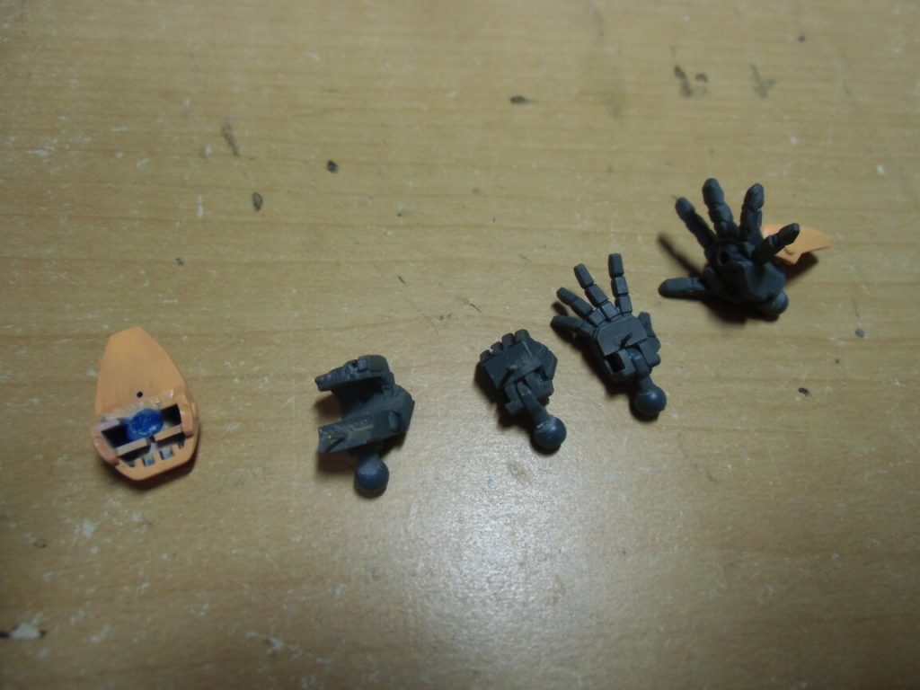 ちょっと見づらいと思いますが、手首の解説。キットの武器持ち手の甲から接続部を削り落とし、ポリパテでツライチに加工。当然武器持ち手との間に隙間ができますが、逆にそこへポリパテを充填。余分なパテを削り落として真鍮線で接続。握り手と平手はビルドナックルズの内部を2mm角棒で埋めてから0.5mmプラ板でかさ上げ。真鍮線接続。手甲側の真鍮線を差す穴はちょうどビームシールド基部の黄色いパーツで隠れるので気になりません。 手首ではなく籠手部分の話なのですが、パーティングラインが六角モールドの上にかかっていて消すのに難儀した人は多いと思います。ここは一度削り落としてプラ板で再構築するのが楽ですが、その際方眼紙に4倍サイズで作図→縮小コピーしてプラ板に貼るという手順を踏むと楽に精度が出せますよ。