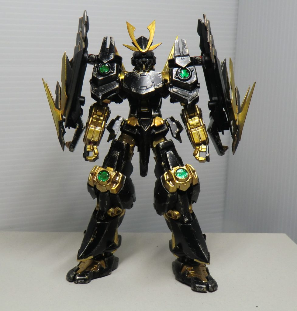 かつてニルスが制作した戦国アストレイのクローン、という設定。オリジナルの再現を試みているものの、オリジナル程のプラフスキー粒子制御技術は持ち合わせていないので、刀身や盾の表面に粒子を定着させて能力向上を図るのみに留まっている。 なおオリジナルにはなかったビーム砲や矛は製作者の戦闘スタイルによるものである。(製作者はニルスほど武芸に長けていた訳では無いのも理由の一つ)・胸板機体の重装化による機動性の低下を盾と同等の防御力を誇る装甲で覆う事で、あえて攻撃を「受ける」事に特化している。盾と同じく定着させた粒子で覆われているので相当硬い。一応リアクティブアーマーとしての機能も持ち合わせている。・臑当とある理由により脚部フレームを覆うように追加された装甲。・草摺(サイドアーマー)追加バーニアとしての機能も持ち合わせた追加装甲。上半身の重装甲化でバランスを取るために下半身の重量も増やしている。 これらの措置は安定して下半身に重心を置ける為、長物である大型矛を扱う上でも重宝する結果となっている。