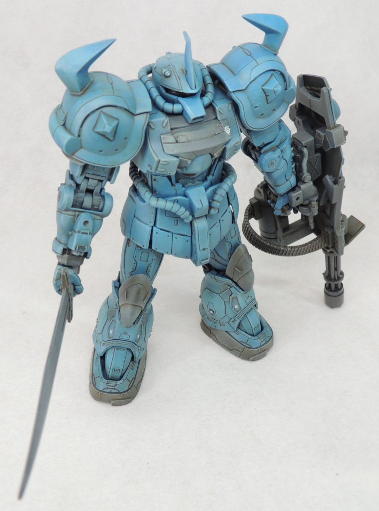 復讐のレクイエムに登場したグフカスタムをイメージソースとし、部分的に設定画の意匠を取り入れて製作しています。頭部は繊細なスジ彫りを行い、プラ材や市販パーツを張り付けてディティールを追加し、モノアイレールはザクⅡソラリ機のものを組み込んでいます。モノアイは塗装後、UVレジンでコートして光沢を出しています。