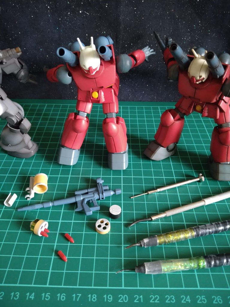 〈ガンキャノン①〉〘おっなんなんなんだこれは!😲〙〈サグフリッパー〉〘なになになになになになになになになに!!!!🤩🤩🤩〙〈ガンキャノン②〉〘…………🤗〙スーパーナパームは百均の習字用の筆やプラパイプ、プラバン等で、〘取り外し出来る〙ように制作しております!😆ビームライフルの左側にあるパーツをビームライフルの先端の溝に〘パチン〙とはめる様に制作しております😁ただ完成後、取り付けたり外したり…😚遊びまくってる時にビームライフルの塗装が剥がれたら😱ヒェーあまりにもショックが大きいと思いましたのでこのスーパーナパーム側のパーツにくっ付いているプラパイプで作った〘C型の部品〙を〘ゆるめ〙に、そしてエッジもとにかく無くし、塗装を削るであろう場所をとにかく丸くしました!😁取り付けはパチンとはめ、そのままでは少しゆるく外れやすいと思いましたので、その左にあるパーツをスライドさせ被せて取り付け完了😆…その後、数回付けたり外したりしましたが、今の所、塗装剥がれはありません!😁ヨカッタ!ビームライフルの下にある赤いパーツは赤いランナーを削って作りました。…そして私、恥ずかしくてお伝えする事ためらっていたのですが…🥴ハスカシッ💦右斜め下にありますのが、私の使っている筋彫りの道具でございます…🥴百均の精密ドライバーの先を鉤爪の様な形に削って〘刃〙をつけ持ち手のとこの六角の部分をもぎ取り😅プラパイプを被せてその後使いやすい太さになるまで、ビニールテープぐるぐる巻いて刃の幅が違うので目印の為の色の異なるキラキラテープ巻いて最後に熱で縮むチュウブで仕上げ…🥴💦作ればまだ増えますが、とりあえず3本で100円でございます…🥴ハズカシッ💦