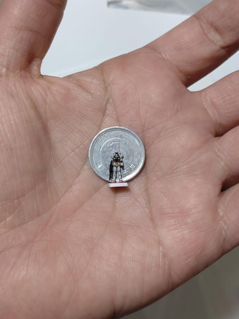 1円玉と記念撮影。測ってみるとガンダムの身長は約11ミリでした。ちなみに台座にしてるプラ板が1.2ミリです。