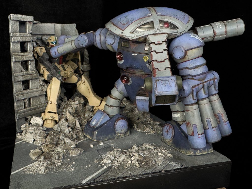 ビルにめり込んだジムは既に眼中になく、ジオラマの外にもいるであろう次の標的を見据えています。