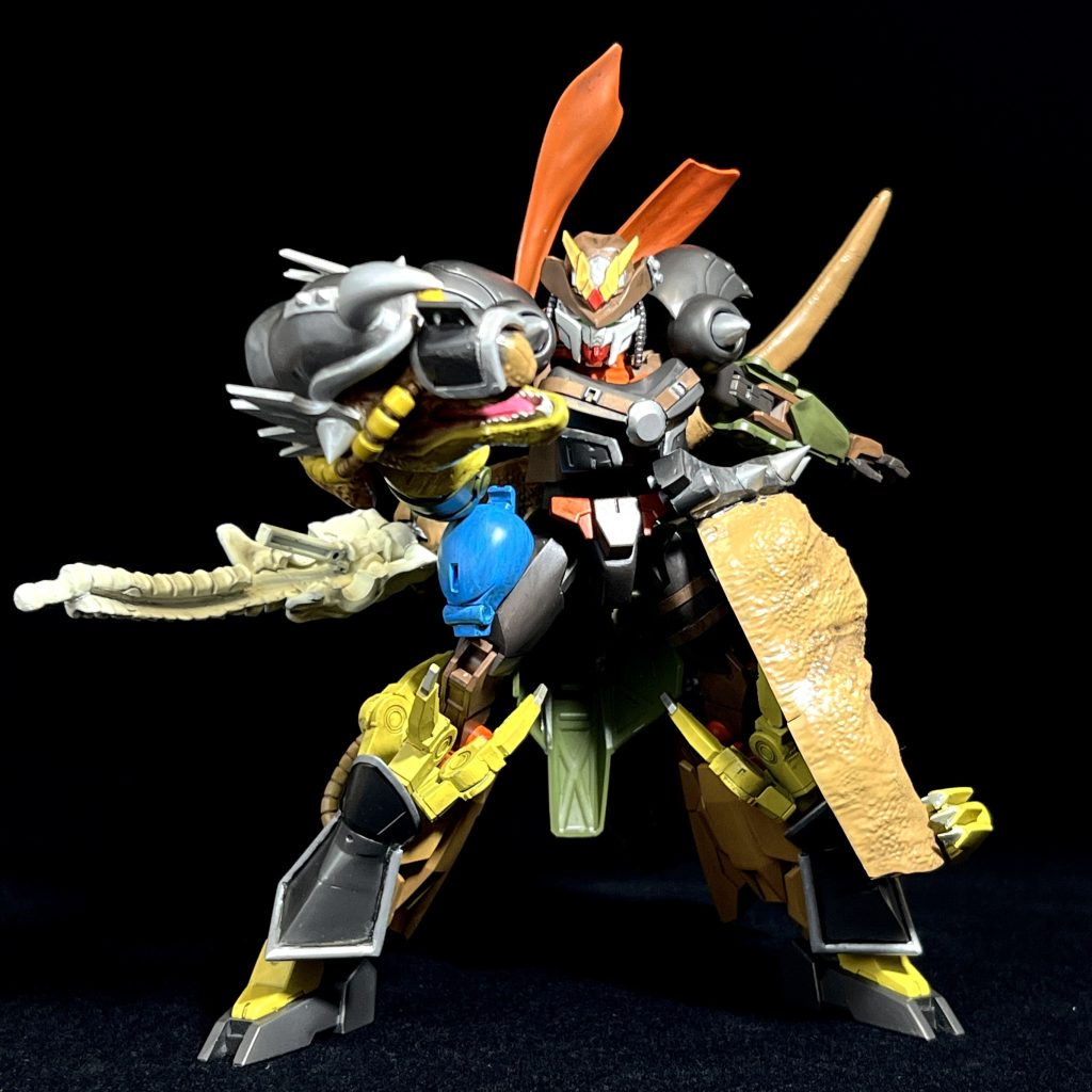 ▲インディライノガンダムコアインディにティラノザクアーマーが合体した形態フェイス部分はフェイクニューの頭部を加工して、ジムの顔に磁石で着くようになっています。メ⚪︎トロンよろしく、ティラノの頭を腕に添えるのは最初に決めたのですが、困ったがティラノの胴体でした。色々と配置を検討した結果、腰マントのように纏う、という方式にしました。アシンメトリーになって気に入っています。