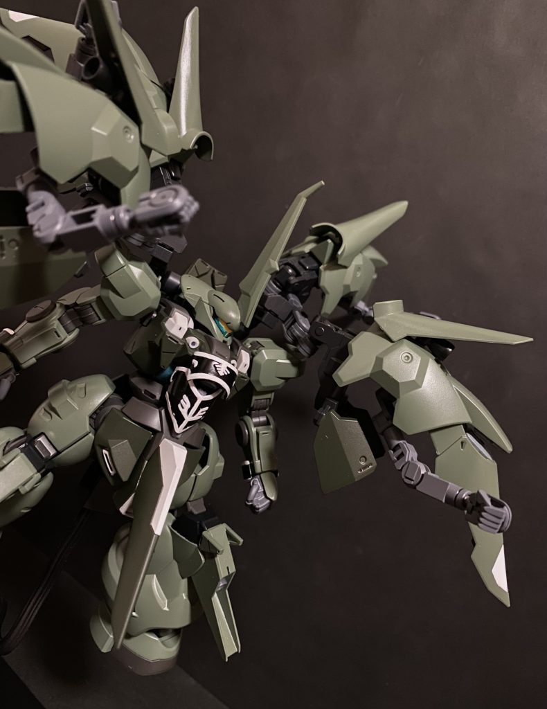 ラージャニヤ　ディランザ･カッティーヤの四枚のバインダーには、それぞれにサブアームが内蔵される。所謂、隠し腕。である。一般にサブアームと言われイメージするのは、細く、貧弱な、あくまで何かのサポートをする為のアームユニットを想像するだろう。しかし、このバインダー内に内蔵されるアームユニットは、スペック的にペイル社のザウォートの腕部とほぼ同等のものであり、バインダー内に懸架したビームライフル及び、ビームトーチを通常の腕部のように使用することができる。まさにその名の通り、ラージャニヤ(両腕を意味する)。この機体、ディランザ･カッティーヤの第二、第三の両腕として機能するのだ。　しかし、欠点もある。通常、人体を模したMSの操縦は、人体の延長という「感覚」ありきで操縦されるものだ。機体に複数の腕を追加する。これは、自分の腕以外の腕を操作する「感覚」が必要になる。腕が六本もある人間はいないだろう。その「感覚」を補うのが、ジェターク社の高度なAI技術なのであり、強化人士であるマリィの操縦技術を持ってしても、非常に難しいのだ。その為、機体の首の後ろ、バックパックの上部に、バインダー及び、サブアームを制御する為のAIシステムを内蔵したユニットが追加されている。