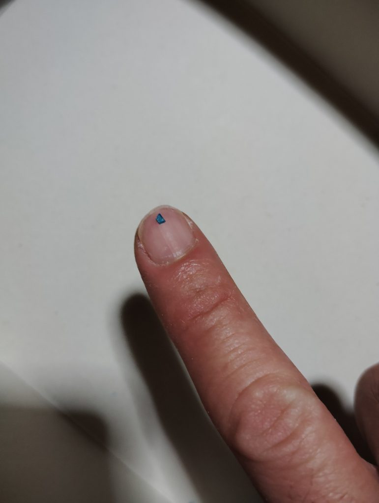 リアカメラの切り出し完了です。 爪の先にちょこんと乗っているのが、ランナータグから切り出したリアカメラのパーツですが、毎度のことながらこのサイズのパーツを、それもムダに固いクリアパーツのランナーから切り出すのは、非常に骨が折れました・・・。
