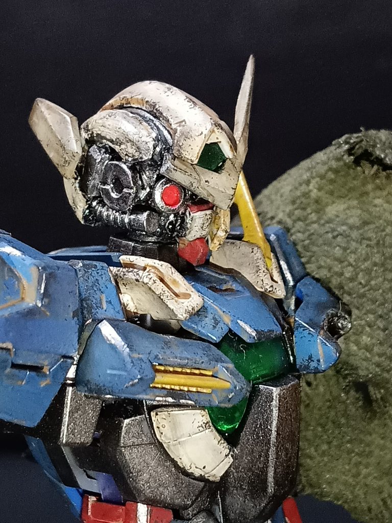 ダメージ→リペアしたような感じを出したかったので、設定よりもダメージ多くしました。欠損パーツは、ただ取れた感じではなくダメージを負って欠損した感じに全筆塗り、グレー下地に各色の色を乗せつつサンディブラウンで汚した感じですその他はファントムグレーやファインシルバーでチッピングや塗装はがれ表現頭部の代替カメラは、ジャンクパーツを埋め込んだんですが、1/144の頭部にフィットして、かつカメラっぽく見えるようになるように、かなり試行錯誤でした。アイ部分は何かの筒状パーツを輪切りにしてクリアパーツ埋め込みましたアンテナは子供と妻に合わせて2回折られましたwちょうどいいパーツ探してたら、未使用糸ようじの反対の尖ってるほうがピッタリでしたw