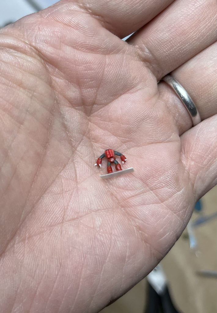 足もちょん切って、スネの膨らみを瞬間接着剤で作って、ズゴックっぽい股の開きにして接着。目の黒いレール(？)部分と胸の排気はディカールの細切りです。