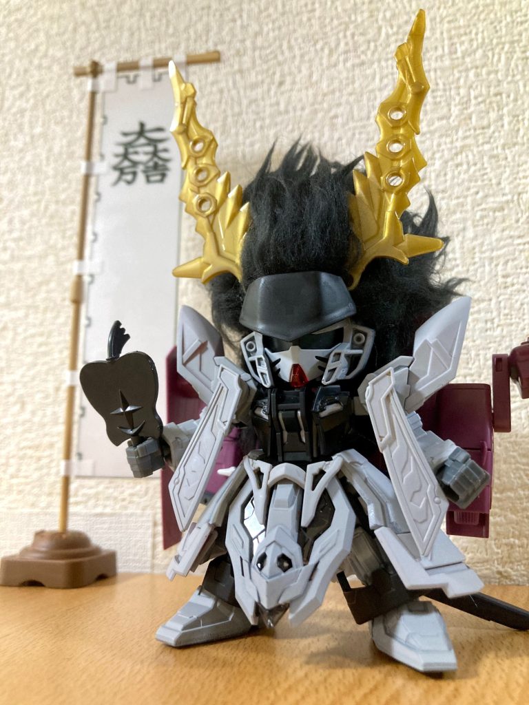 最も特徴的な頭部の乱髪は、手芸用ファー素材のうち毛束や色や質感が一番イメージに近いと思われたプードルボアという素材を用いて、プラモ側の頭部形状に合わせて8つの生地に分割し、毛の流れる方向や長さ・ボリュームを整えた上で、布用テープと組み合わせた植毛シールのような状態で接着しています。