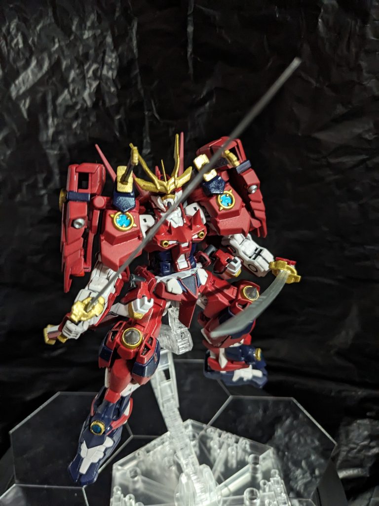 そんな彼が自分のプレイを反芻していると、ふと気が付いた。「なんで私は腕を2本しか使っていなかった?」戦国アストレイは隠し腕を合わせて四本の腕があるが、大会でニルスは二本ずつしか使っていなかった。何なら後方師匠面で腕組みしていた。