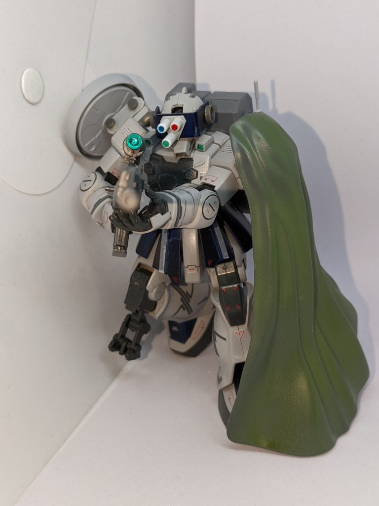 狙撃のポーズです。ライフルは30MMのレンズパーツでより近代的な狙撃銃にしました。ちなみに実弾仕様です。左肩のマントは迷彩布であり狙撃時の隠蔽を目的にしています。遠距離で敵機に向かって狙撃による一方的な撃破、そして狙撃位置がバレぬよう高速移動で動き想定外な場所での狙撃をも可能とする機体です。