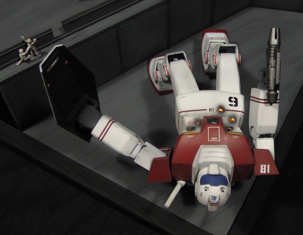 1/100リアルタイプジムが、かろうじて両脚でふんばっています。お腹の弾痕は、6発分。2斉射のようですね。内部でかすかに光るのは、娘のおもちゃを加工したLEDライトです。